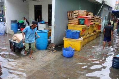 Anak-anak bermain luapan air laut yang menggenangi dermaga di pulau Panggang Kepulauan Seribu Utara, Provinsi DKI Jakarta, Selasa (7/12/2021).