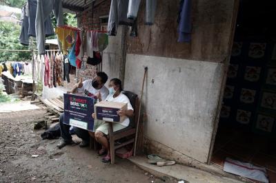 Perwakilan GoTo didampingi tim SalamAid, Ketua RW dan tim relawan, menyerahkan paket sembako pada warga di kawasan Semarang Tengah.