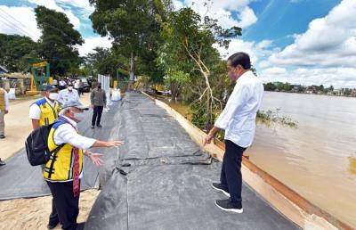 Presiden Jokowi meninjau geobag dan geotub penahan banjir di Kalurahan Ladang, Kabupaten Sintang, Kalimantan Barat, Rabu (8/12/2021).
