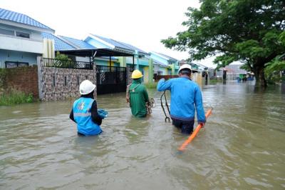 Petugas PLN melintas di tengah banjir Perumnas Antang, Blok 10, Kecamatan Manggala, Makassar, Rabu (8/12/2021).