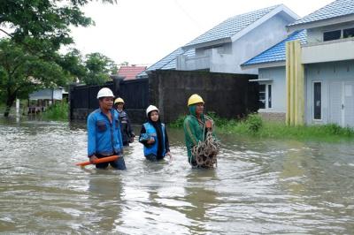 Petugas PLN melintas di tengah banjir Perumnas Antang, Blok 10, Kecamatan Manggala, Makassar, Rabu (8/12/2021).