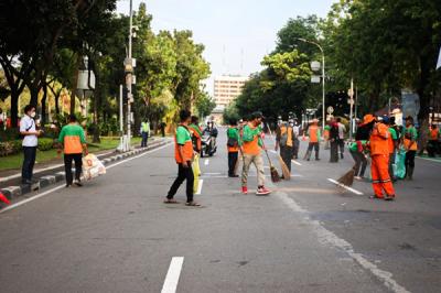 Sejumlah petugas gabungan PPSU dan Dinas Lingkungan Hidup gerak cepat membersihkan sampah sisa unjuk rasa buruh di Jalan Merdeka Selatan.