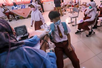 Tenaga kesehatan menyuntikkan vaksin Covid-19 kepada pelajar di SDN Cempaka Putih Timur 03, Jakarta Pusat, Selasa (14/12/2021).