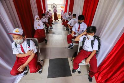 Tenaga kesehatan menyuntikkan vaksin Covid-19 kepada pelajar di SDN Cempaka Putih Timur 03, Jakarta Pusat, Selasa (14/12/2021).