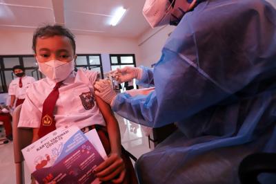 Tenaga kesehatan menyuntikkan vaksin Covid-19 kepada pelajar di SDN Cempaka Putih Timur 03, Jakarta Pusat, Selasa (14/12/2021).