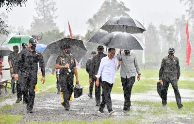Presiden Joko Widodo basah kuyup meski berpayung usai penanaman cabai bersama masyarakat di Food Estate, Desa Lamuk, Wonosobo, Jawa Tengah, Selasa (14/12/2021).
