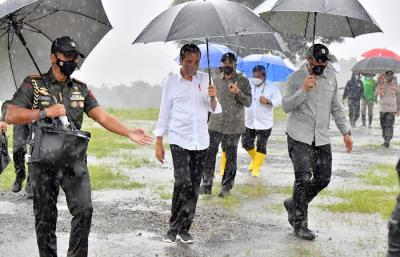 Presiden Joko Widodo basah kuyup meski berpayung usai penanaman cabai bersama masyarakat di Food Estate, Desa Lamuk, Wonosobo, Jawa Tengah, Selasa (14/12/2021).