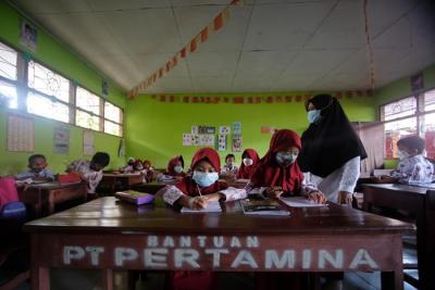 Sejumlah murid menggunakan perahu saat melintasi area persawahan yang terendam banjir di Kelurahan Tamangapa, Makassar, Rabu (15/12/2021).