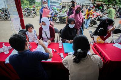 Seorang anak menunjukan Kartu Identitas Anak (KIA) miliknya di Kecamatan Tapos, Depok, Jawa Barat, Jumat (17/12/2021).