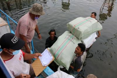 Anak buah kapal ojeg tradisional tujuan Kaliadem kepulauan seribu mengangkut logistik yang akan diangkut ke dalam kapal atau ojeg di Pelabuhan Kali Adem.