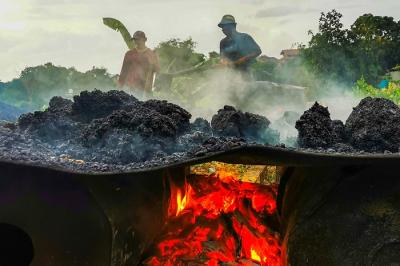 Potret Para pekerja sedang menggoreng campuran pasir dan campuran aspal secara manual di lahan kosong, Bandung, Jawa Barat, Minggu (19/12/2021).