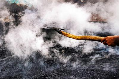 Potret Para pekerja sedang menggoreng campuran pasir dan campuran aspal secara manual di lahan kosong, Bandung, Jawa Barat, Minggu (19/12/2021).