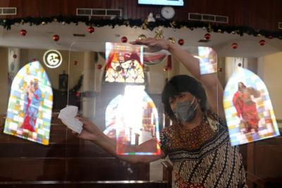 Pengurus panitia Natal membersihkan area Gereja Katedral, Makassar, Senin (20/12/2021).