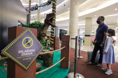 Pengunjung menyaksikan replika hewan prasejarah dalam wahana Dino Factory by Dino Island di Mal Kota Kasablanka, Jakarta Selatan, Senin (20/12/2021).
