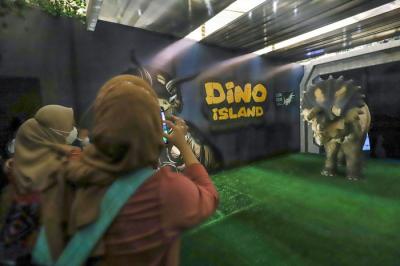 Pengunjung menyaksikan replika hewan prasejarah dalam wahana Dino Factory by Dino Island di Mal Kota Kasablanka, Jakarta Selatan, Senin (20/12/2021).
