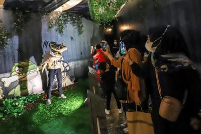 Pengunjung menyaksikan replika hewan prasejarah dalam wahana Dino Factory by Dino Island di Mal Kota Kasablanka, Jakarta Selatan, Senin (20/12/2021).