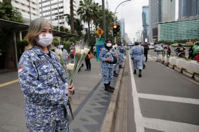 Sejumlah perserta aksi yang tergabung dalam Forum Kader Bela Negara DKI Jakarta menggelar aksi membagikan bunga dan masker kepada pengguna jalan.