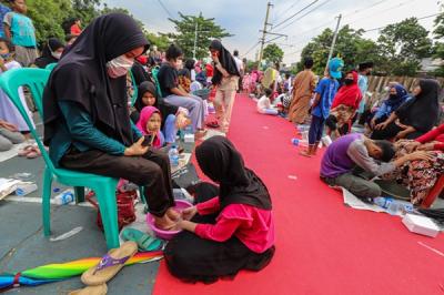 Seorang anak mencuci kaki ibu dalam kegiatan bertajuk 