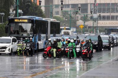 Pengendara melintas di jalan saat hujan di kawasan Imam Bonjol, Jakarta, Kamis (23/12/2021).