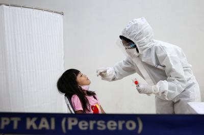 Petugas kesehatan melakukan tes swab PCR pada seorang anak di Stasiun Pasar Senen, Jakarta, Kamis (23/12/2021).