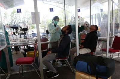 Petugas kesehatan melakukan tes swab PCR pada seorang anak di Stasiun Pasar Senen, Jakarta, Kamis (23/12/2021).