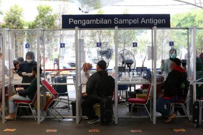 Petugas kesehatan melakukan tes swab PCR pada seorang anak di Stasiun Pasar Senen, Jakarta, Kamis (23/12/2021).