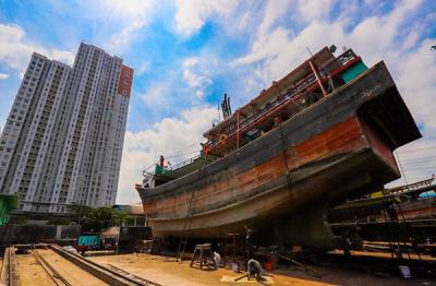 Aktivitas pekerja saat memperbaiki kapal di sebuah galangan kapal kawasan Muara Angke, Jakarta Utara, Rabu (22/12/2021).
