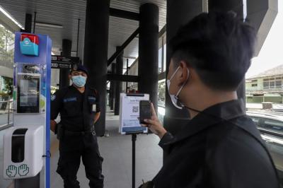 Warga memindai kode batang menggunakan aplikasi PeduliLindungi sebelum memasuki Halte Integrasi Centrale Stichting Wederopbouw (CSW).