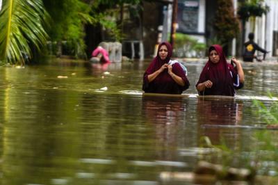 Hujan deras yang menguyur Kota Palembang membuat banyak kawasan terendam banjir bahkan yang jarang banjirpun ikut tergenang, Sabtu (25/12/2021).