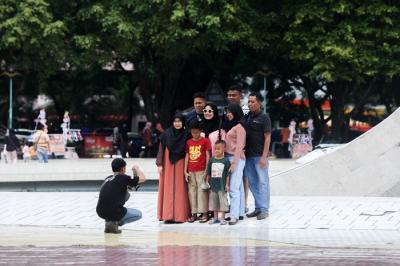 Pengunjung mengantre untuk masuk ke Taman Mini Indonesia Indah (TMII) di Jakarta Timur, Sabtu (25/12/2021).