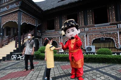 Pengunjung mengantre untuk masuk ke Taman Mini Indonesia Indah (TMII) di Jakarta Timur, Sabtu (25/12/2021).