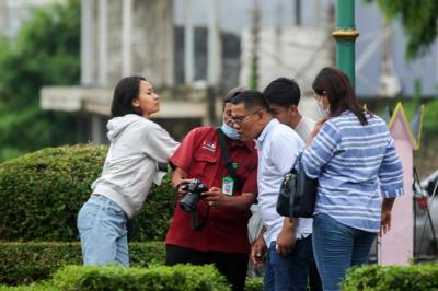 Juru foto saat mengarahkan gaya pengunjung yang mengunakan jasanya di Taman Mini Indonesia Indah (TMII), Jakarta Timur, Sabtu (25/12/2021).