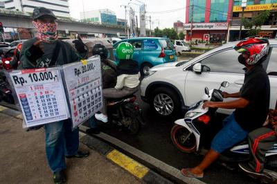 Pedagang musiman menawarkan kalender 2022 kepada pengendara di lampu merah kawasan, Jakarta Pusat, Selasa (28/12/2021).