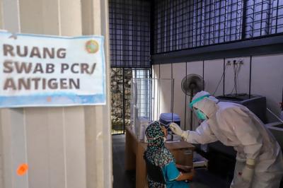 Petugas kesehatan melakukan tes usap (swab test) PCR kepada warga di Puskesmas Kecamatan Mampang Prapatan, Jakarta Selatan, Selasa (28/12/2021).