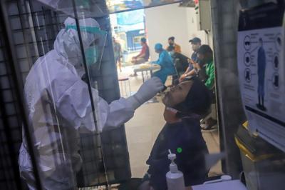 Petugas kesehatan melakukan tes usap (swab test) PCR kepada warga di Puskesmas Kecamatan Mampang Prapatan, Jakarta Selatan, Selasa (28/12/2021).