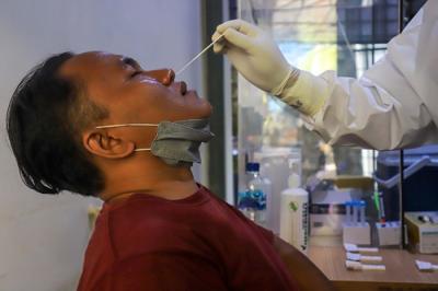 Petugas kesehatan melakukan tes usap (swab test) PCR kepada warga di Puskesmas Kecamatan Mampang Prapatan, Jakarta Selatan, Selasa (28/12/2021).