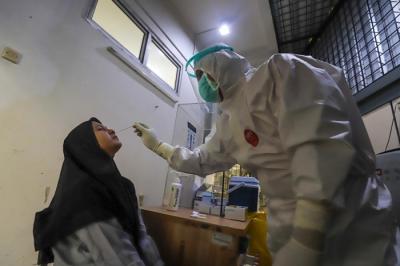 Petugas kesehatan melakukan tes usap (swab test) PCR kepada warga di Puskesmas Kecamatan Mampang Prapatan, Jakarta Selatan, Selasa (28/12/2021).