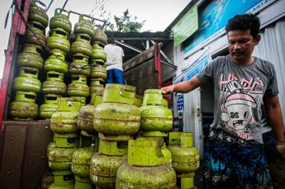 Pekerja saat menurunkan tabung gas ukuran 3 kilogram di agen gas kawasan Lubang Buaya, Jakarta Timur, Rabu (29/12/2021).