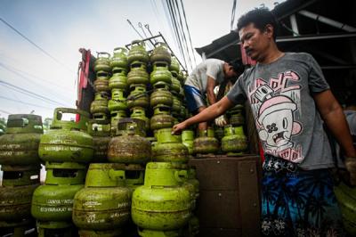 Pekerja saat menurunkan tabung gas ukuran 3 kilogram di agen gas kawasan Lubang Buaya, Jakarta Timur, Rabu (29/12/2021).