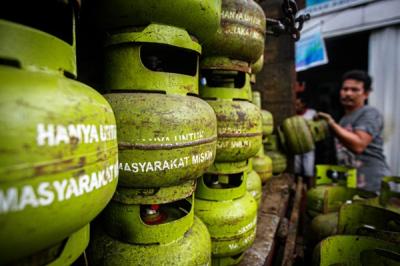 Pekerja saat menurunkan tabung gas ukuran 3 kilogram di agen gas kawasan Lubang Buaya, Jakarta Timur, Rabu (29/12/2021).