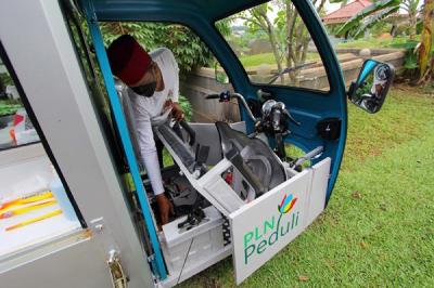 Pedagang Es Selendang Mayang Bang Hafidz dengan menggunakan Moto Listrik (MOLIS) dari PLN Peduli melayani pembeli di kawasan Makam Tionghoa di Cimanggis.