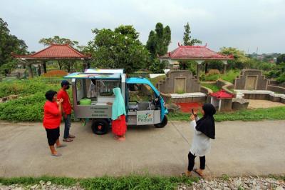 Pedagang Es Selendang Mayang Bang Hafidz dengan menggunakan Moto Listrik (MOLIS) dari PLN Peduli melayani pembeli di kawasan Makam Tionghoa di Cimanggis.