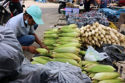 Pedagang jagung melayani pembeli di kawasan Pasar Ikan Muara Angke, Jakarta Utara, Jumat (31/12/2021).