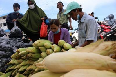 Pedagang jagung melayani pembeli di kawasan Pasar Ikan Muara Angke, Jakarta Utara, Jumat (31/12/2021).