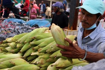 Pedagang jagung melayani pembeli di kawasan Pasar Ikan Muara Angke, Jakarta Utara, Jumat (31/12/2021).
