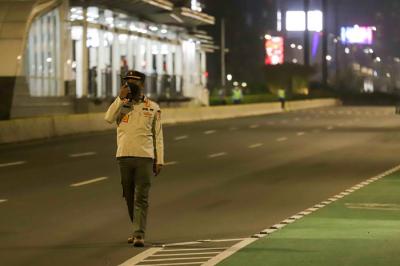 Petugas gabungan membubarkan kerumunan warga saat pemberlakukan Crowd Free Night di Kawasan Bundaran HI, Jakarta Pusat, Jumat (31/12/2021).