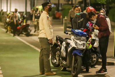 Petugas gabungan membubarkan kerumunan warga saat pemberlakukan Crowd Free Night di Kawasan Bundaran HI, Jakarta Pusat, Jumat (31/12/2021).