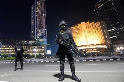 Sejumlah personel Satbrimob Polda Metro Jaya berjaga saat pemberlakuan Crowd Free Night di Bundaran Hotel Indonesia, Jakarta, Jumat (31/12/2021).