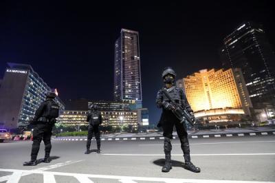 Sejumlah personel Satbrimob Polda Metro Jaya berjaga saat pemberlakuan Crowd Free Night di Bundaran Hotel Indonesia, Jakarta, Jumat (31/12/2021).
