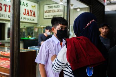 Penjual seragam sekolah saat melayani pembeli di Pasar Embrio, Kampung Makasar, Jakarta Timur, Minggu (2/1/2022).